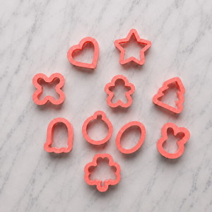 A set of 10 mini cookie cutters to pair with the Tic Tac Toe cookie stencil, shapes include X and heart, star, shamrock, ghost and pumpkin and egg and bunny head