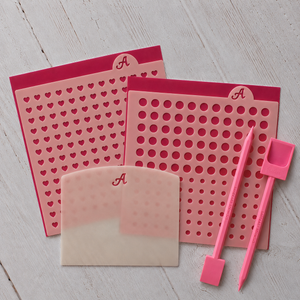 Make Your Own Sprinkles Starter Set includes a Polka Dot Sprinkles stencil with two sizes or circles, Heart Sprinkles Stencil, an Icing Scraper, and the Sweep and Scoop tools set.