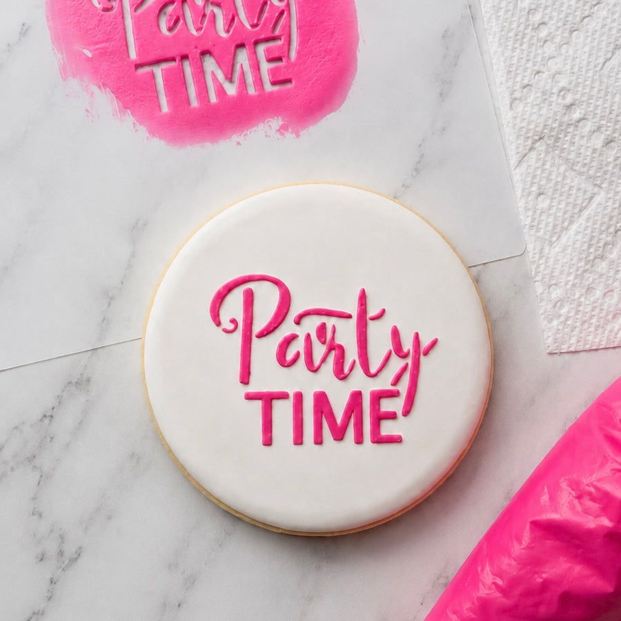 A white round sugar cookie decorated with our Party Time Cookie Stencil in hot pink royal icing