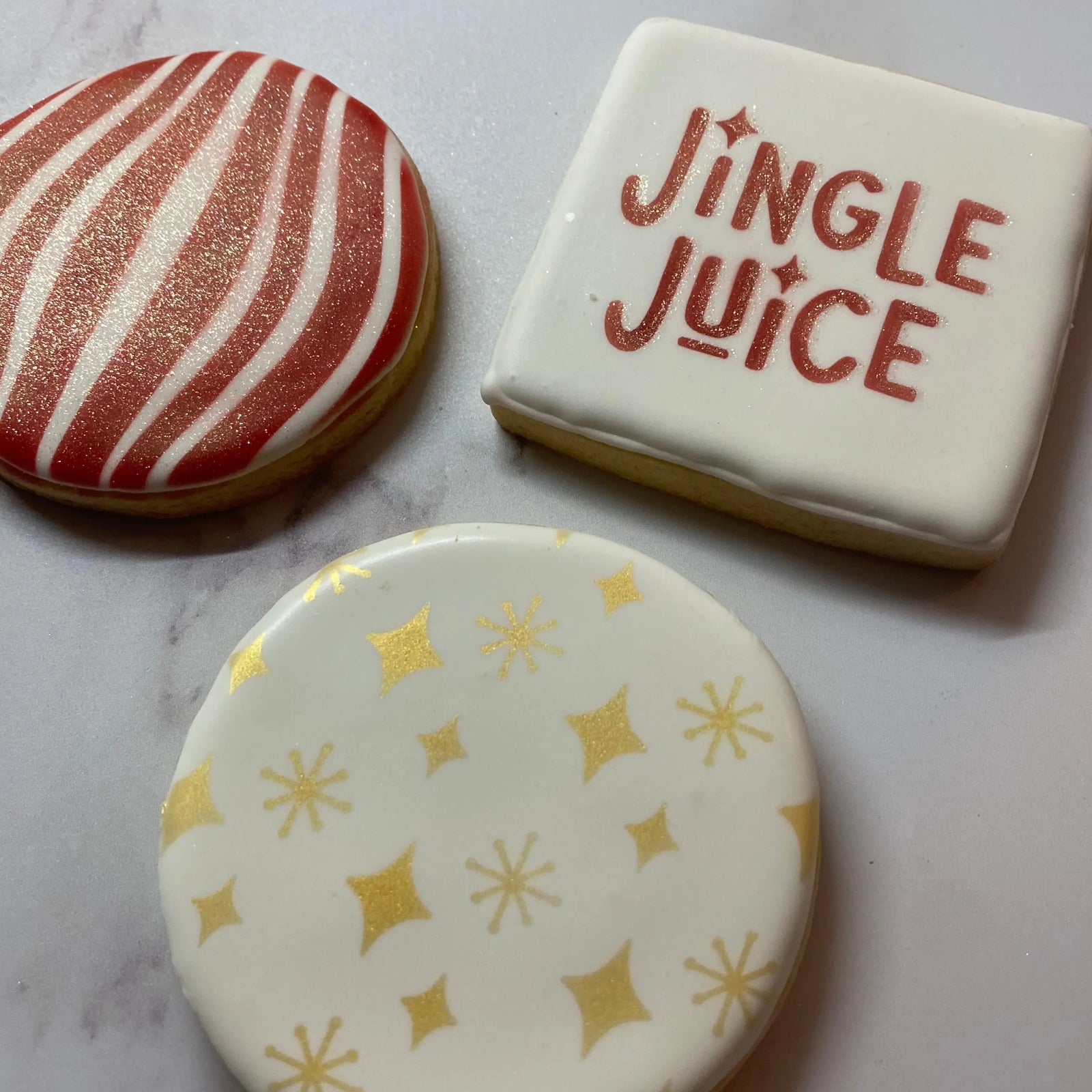 three round sugar cookies decorated with the Winter Stencil Set inspired by Garty Goodies in gold and red